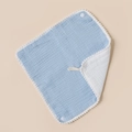 Detail view of double-sided cotton baby bib with pompom trim, snap button and lanyard - Sky Blue And White