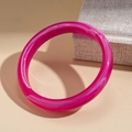 Detail eines pinkfarbenen Acryl-Armreifs mit weißer Marmorierung auf einer Schmuckbox - Rosa