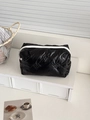 Glossy black quilted bow pattern makeup bag with contrast white zipper on display - Without Charm / Black