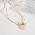Detalle de dijes de concha y estrella de mar en un collar de cuentas para la playa - Estrella de Mar Rosa