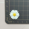 Detailed size measurement of 2.3cm white resin daisy charm on a black grid cutting mat - Closed Daisy