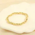 Detailed macro view of faceted golden beaded bracelet on a white scallop ceramic plate - BR1683-E/Gold Hammered Faceted Beads