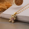Primer plano del colgante de oso chapado en oro con circonitas cúbicas rojas y transparentes - Dorado/Circonita Roja