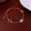 Macro detail of golden gourd bracelet with green gemstone and pavé stones on red velvet - 5# Bracelet-Gold