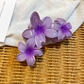 Détail de la pince à cheveux fleurie en acrylique violet sur fond tissé rustique - Violet