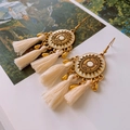 Boucles d'oreilles bohèmes avec médaillon soleil doré et pompons blancs soyeux - Crochets d'oreilles médaillon soleil doré à pompons