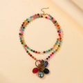 Detail of colorful beads and handcrafted aluminum wire floral pendant on a layered necklace - Colorful