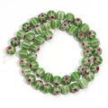 Macro shot of green millefiori glass beads arranged in a circle for DIY jewelry making - Green Red Flower