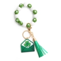 Close-up of Saint Patrick's Day wood bead keychain with shamrock pattern and leather tassel - US 3