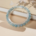 Close-up of light blue aquamarine beaded bracelet on acrylic stand with book background - 6mm Specification (With Gift Box)
