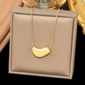 Luxurious gold bean heart pendant necklace displayed on a beige jewelry box - Geometric Heart / Gold