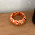 Détail du bracelet en résine marbrée orange avec intercalaires dorés sur bois - Orange