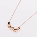 Detalle del collar de trébol en oro rosa con cinco pequeñas flores con incrustaciones - Diseño de flores conectadas / Oro rosa
