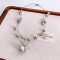 Macro shot of double-layer necklace with grey pearls and heart-shaped zircon pendant - Silver-Grey