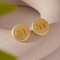 Macro di orecchini a bottone dorati con lettera m in rilievo e finitura opaca - Perno in Argento - Orecchini a Bottone Tondi Dorati Lettera M