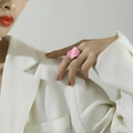 Close-up of a pink enamel irregular ring with gold trim worn by a model in soft lighting - Adjustable Open / Gold Pink Enamel