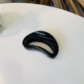 Close-up of a glossy black semicircular hair claw clip on a clean white surface - Approx 7cm / Glossy Black
