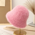 Plush faux fur bucket hat in soft pink displayed on a luxury golden metal stand - Rose Red