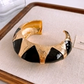 Detail of vintage gold open bangle with black enamel oval and wavy metal texture - Wide Version / Gold/Black