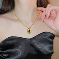 Gros plan d'un collier goutte d'or avec pierre précieuse rouge et diamants étincelants - 73# Collier - Collier chaîne serpent à pierre précieuse rouge goutte d'eau dorée