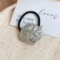 Detail shot of silver seashell hair tie with starfish pattern on textured stone - Shell Starfish / Silver