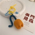 Handmade crochet orange tulip keychain with blue stem and colorful clasp on ceramic tray - Orange Blue