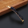 Minimalist gold hair clip with deep blue natural crystal stones on a dark background - Blue Sandstone Gold
