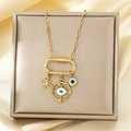 Detailopname van gouden Evil Eye ketting met ster- en maanbedels op zijden stof - Gouden Ster Maan Evil Eye Stijl (KN293246-SXSJ)