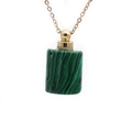 Detail of green malachite cylinder perfume bottle pendant with golden metal cap and chain - Malachite