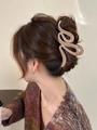Dettaglio del grande fermaglio per capelli opaco da 13 cm color kaki su un'acconciatura - Beige