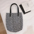 Détail du sac cabas en toile florale avec anses en similicuir noir et rivets en métal - Noir Fleuri