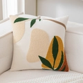 Cream velvet cushion cover with yellow and green tufted leaf patterns on a soft sofa - Leaf