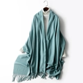 Teal green knitted wool shawl with fringe tassels over a white turtleneck sweater - Haze Blue