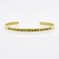 Golden 4mm stainless steel cuff bracelet engraved with She Is Clothed In Strength and Dignity - She Is Clothed In Strength and Dignity