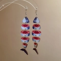 Dettaglio degli orecchini creativi a lisca di pesce con stampa in legno e nappe colorate - Blu