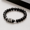 Detailed macro view of matte black beads with a silver skull charm on an elastic bracelet - Matte Black Agate (KB183253-TLX)