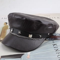 Detalle de gorra newsboy de cuero marrón oscuro con cadena metálica y tachuelas de estrella - Talla Única 57cm / Marrón Cadena con Estrellas