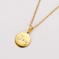 Macro shot of 18k gold plated round pendant with engraved Joy on stainless steel necklace - Gold (Joy Engraved)