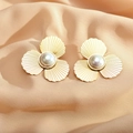 Elegante goldene Blumenohrringe mit Perle auf champagnerfarbenem Satin-Hintergrund - Goldene Form mit drei Blütenblättern