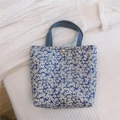 Detailaufnahme der blauen geblümten Lunchtasche mit weißem Blumenmuster und Goldknopf - Kleinblau Floral