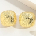 Detailed macro shot of square gold earrings with a shimmering hammered texture finish - Hammered Texture Style