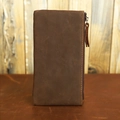 Macro detail of brown leather wallet showing stitching and metal zipper on wood background - Crazy Horse Brown Coarse Texture