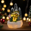 Lighted Christmas cottage with Santa Claus and snow-covered trees for holiday decor - Santa Claus with Gift Bag Snow House