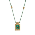 Macro shot of gold-plated hummingbird tarot pendant with green enamel and braided cord - Woodpecker Necklace