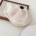 Elegant cream beige satin hair claw clip with golden accent on wooden display tray - Beige