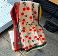 Beige cashmere-like scarf with red cherry pattern and tassels hanging on a chair - Red