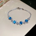 Detailed close-up of luxury silver butterfly bracelet with blue gemstones and diamonds - Sky Blue Oval Zircon Style / Blue