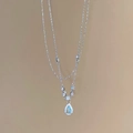 Detalle del collar plateado con colgante de gota de agua azul y cristales incrustados - Colgante de Gota de Agua Azul / Plateado/Azul
