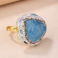 Anillo dorado ajustable con piedra bruta azul claro y borde de strass brillante - Aguamarina Azul Claro