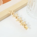 Matte gold hair clip featuring four small five-petal flowers in a minimalist layout - No. 02 Duckbill Clip (Four Flowers)